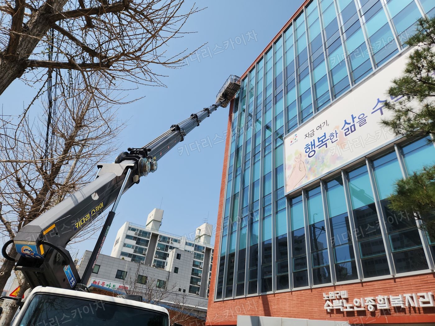 유리 외벽 앞 스카이차 작업대 배치