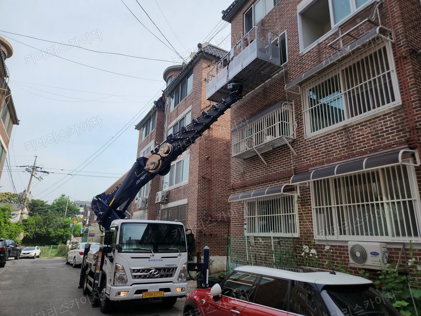 벽돌 건물 앞 스카이차 배치
